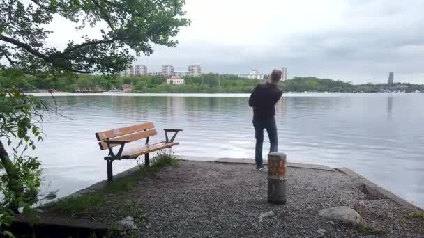 Людина Кам Яному Мосту Пропускає Каміння Спокійну Воду — стокове відео