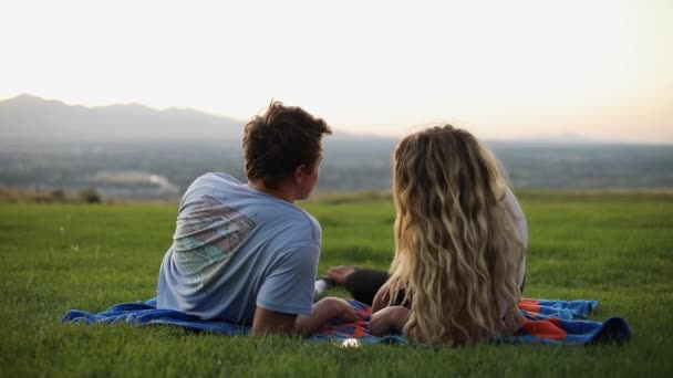 被可爱的男朋友和女朋友躺在毛毯上在草地上野餐时拍的照片 — 图库视频影像