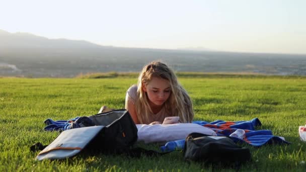 Снимок Красивой Молодой Женщины Лежащей Одеяле Траве Парке Девушка Смотрит — стоковое видео