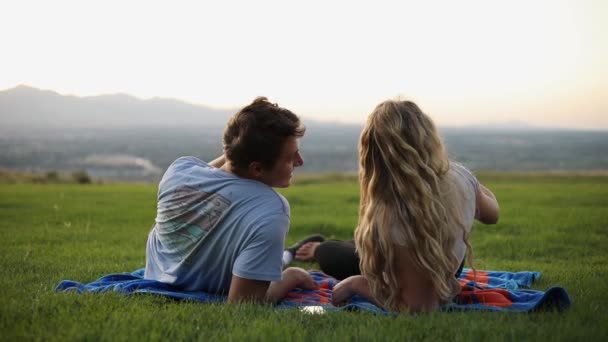 可爱的男朋友和女朋友躺在毛毯上在草地上野餐的慢镜头 — 图库视频影像
