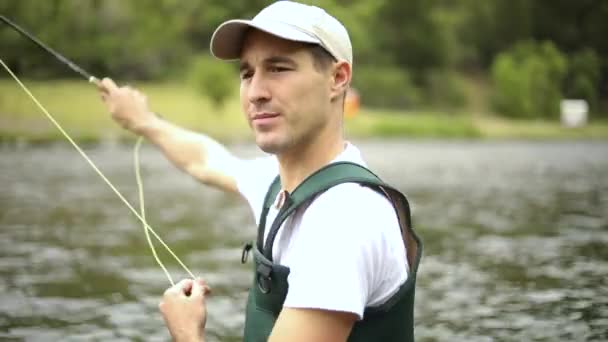 拍了一个白人男性渔夫扔他的钩子而飞鱼 他站在犹他州普罗沃河的中间 — 图库视频影像