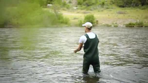 Strzał Białego Rybaka Rzucającego Haczyk Podczas Wędkowania Stoi Środku Rzeki — Wideo stockowe