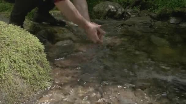 Άνθρωπος Πλένει Χέρια Του Ένα Ρυάκι Του Βουνού Ενώ Ορειβασία — Αρχείο Βίντεο