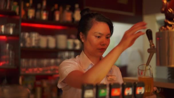 Asian waitress pouring beer at Asian restaurant