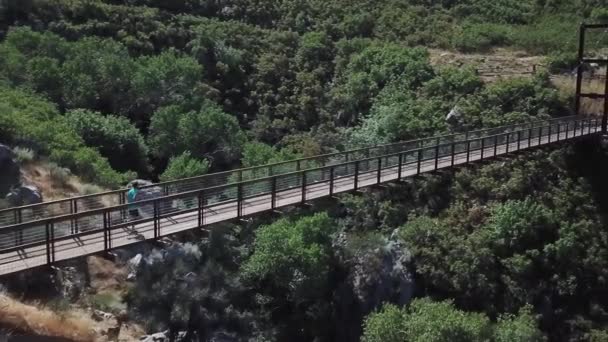 Drone Shot Sigue Hombre Activo Corriendo Puente Colgante Aire Libre — Vídeos de Stock