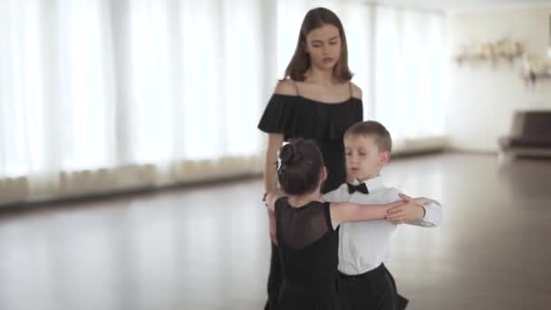 可愛い男の子と女の子の子供たちを授業で踊るレッスンを与える美しい若いダンス教師のハンドヘルドショット — ストック動画