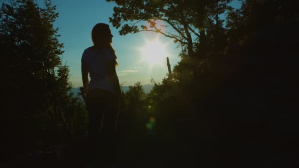 美しい少女は山の頂上で夕日を見て — ストック動画