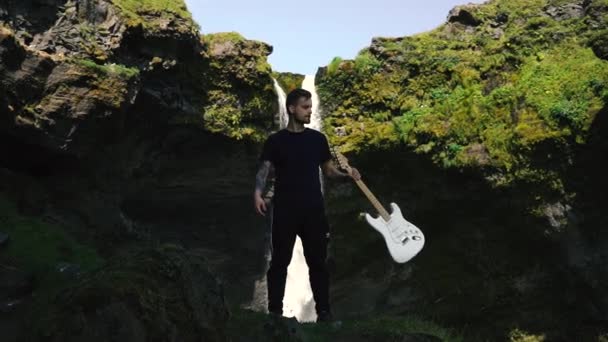Mannen Som Spelar Gitarr Framför Ett Vackert Vattenfall Island Slowmo — Stockvideo