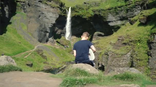 Homem Tocando Guitarra Frente Uma Bela Cachoeira Islândia Slowmo Fotos — Vídeo de Stock