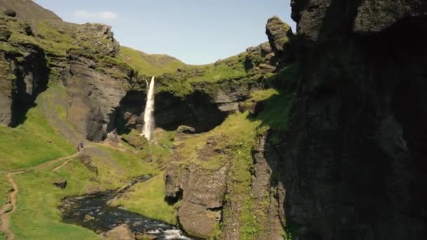 アイスランドの美しい滝の前でギターを弾く男 ソニーA7IiiとRonin Sからのスローモーションとリアルタイムショット — ストック動画