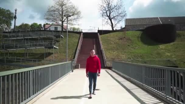 Anak Muda Berdiri Jembatan Ketika Kamera Berada Dekatnya Mengangkat Tangannya — Stok Video