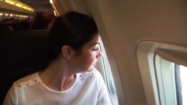 Jeune Fille Dans Avion Regarde Par Fenêtre — Video