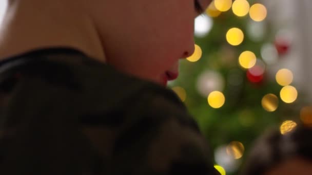 幼児の男の子と母親はクリスマスのためにジンジャーブレッドハウスを飾る 幼児の顔にクローズアップ — ストック動画