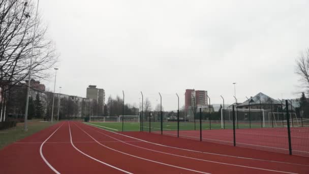 Mladý Muž Přijde Stadion Přiloží Sluchátka Uším Otočí Začne Trénovat — Stock video