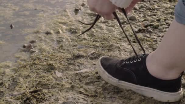 スニーカーポンプの靴ひもを結ぶ水辺のランナー — ストック動画