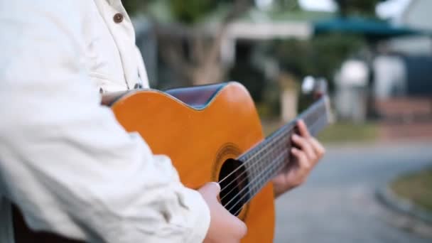 Young Male Artist Walking Street While Playing Acoustic Guitar — Stock Video