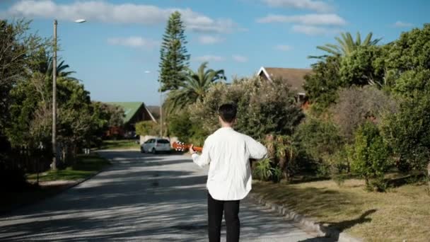 Giovane Uomo Che Cammina Strada Mentre Suona Una Chitarra Acustica — Video Stock