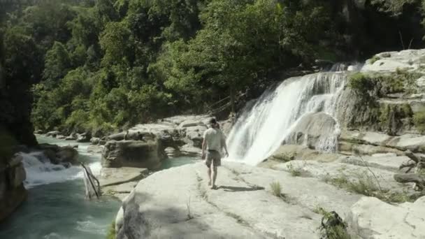 Zdjęcie Drona Człowieka Patrzącego Wodospad Tanggedu Sumbie Otoczonego Drzewami Środku — Wideo stockowe