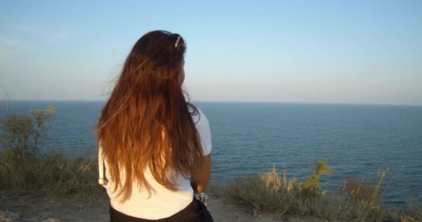 Mädchen Blickt Bei Windigem Wetter Auf Das Meer Bei Sonnenuntergang — Stockvideo