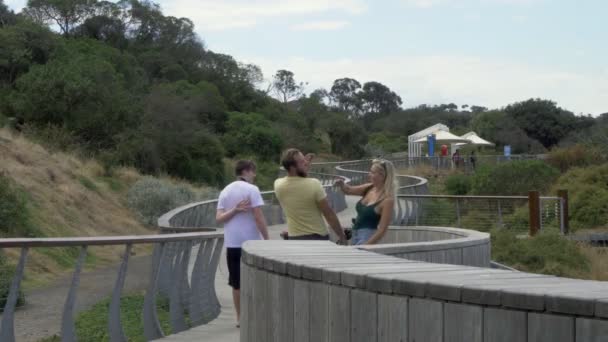 Familie Fuß Holzpromenade Männchen Schlägt Weibchen Ins Gesäß Weibchen Reagiert — Stockvideo