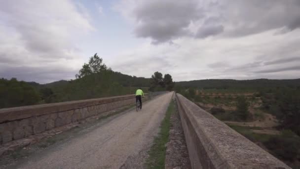 Hombre Ciclista Está Montando Largo Puente Pedregoso — Vídeo de stock