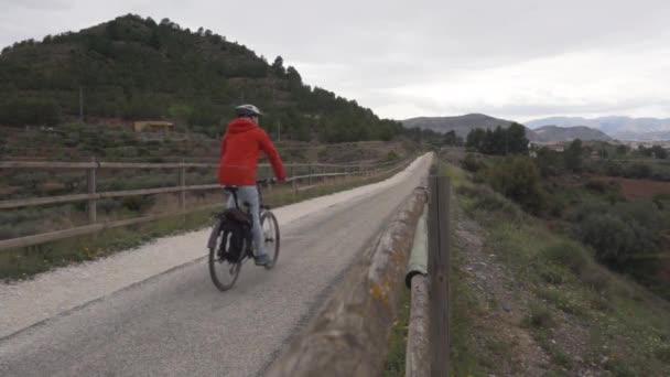 Erkek Bisikletçi Dağ Manzarasında Taştan Bir Köprü Boyunca Gidiyor — Stok video