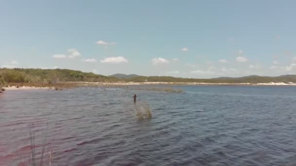 女性だけで美しいフレーザー島では 湖Boomanjin立っている 女性を通過する低角度の空中ビュー — ストック動画