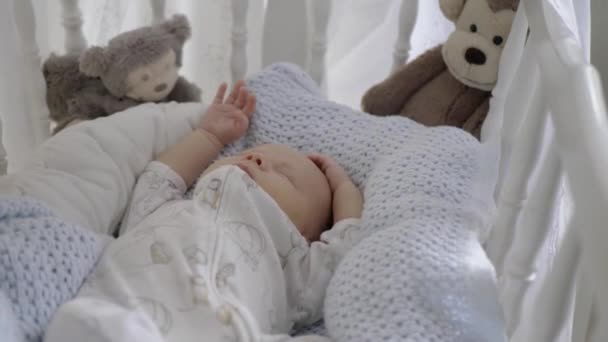 可爱的新生男婴睡着了 睡在舒适的小床上 婴儿床角落里的猴玩具 — 图库视频影像