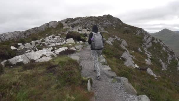 スローモーションガールウォーキングのドリーショット アイルランドのダイヤモンドの丘の上のトレイルのConnemara国立公園でのハイキング — ストック動画