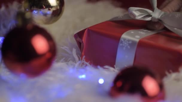 Unwrapping Christmas Gift Wrapped Red Paper Bow Red Bauble — Stock Video