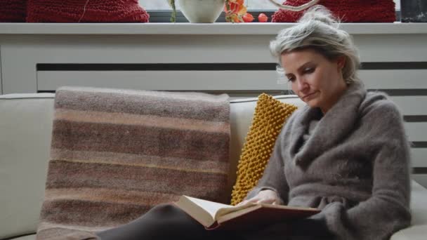 読書を勉強している若い女性のドリーと彼女のリビングルームで笑顔ながらページをめくる — ストック動画