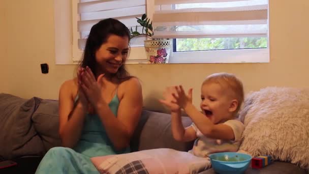 母親Clappingとともに彼女の小さな娘オンザカウチ — ストック動画