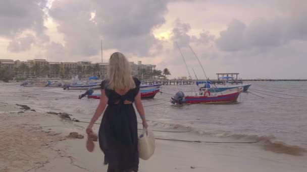 ブロンドの女の子がビーチを歩き回り カメラ 係留ボート リラックスしたメキシコの村を見て回ります — ストック動画