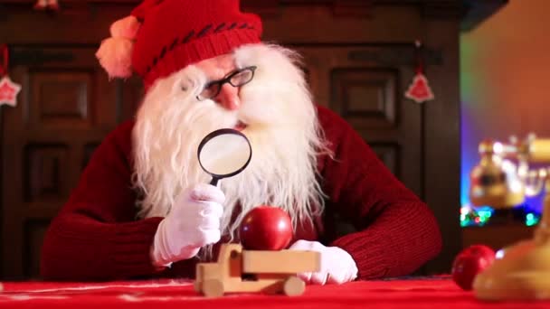 Santa Claus Magnifying Glass Inspects Apples Wooden Toy Truck — Stock Video