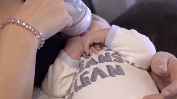 漂亮的男婴靠奶瓶喂着妈妈的膝盖喝水 — 图库视频影像