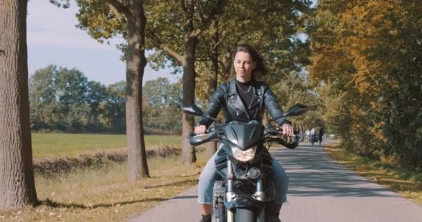 Śliczna Uśmiechnięta Młoda Europejka Jeżdżąca Motocyklem Skórzanej Kurtce Lesie Żywymi — Wideo stockowe