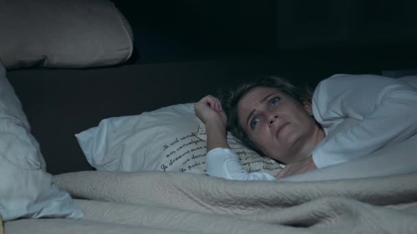 女人躺在床上害怕 害怕暴风雨的雷声和藏在被单下面的闪电 — 图库视频影像
