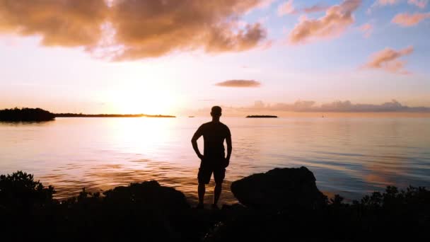 Man Die Voor Zonsondergang Aan Het Water Staat — Stockvideo