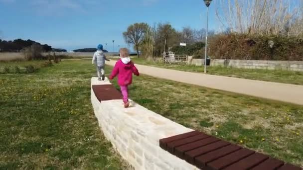 Dos Niños Pequeños Corriendo Largo Pared Piedra Antes Saltar Sobre — Vídeo de stock