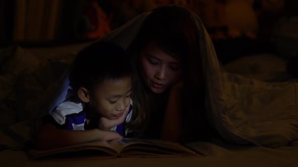 Krásná chvíle, když máma čte knihu se svým dítětem, vypráví mu pohádky na dobrou noc.