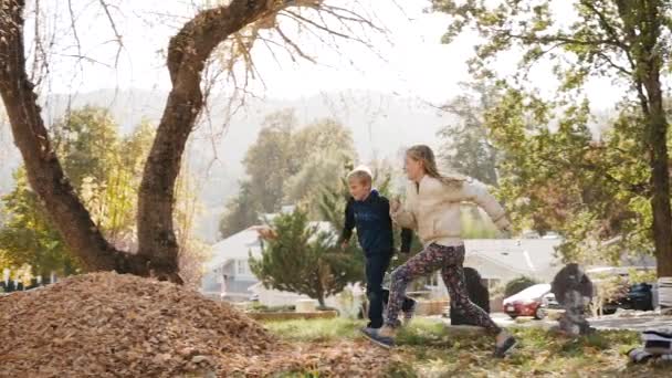 Dos Niños Corren Saltan Montón Hojas Disparo 120Fps Slowmo — Vídeo de stock