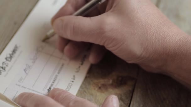 手形を支払うために銀行小切手を書く手 — ストック動画