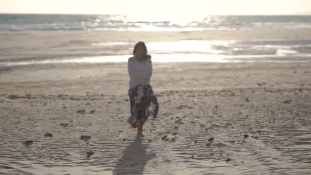 年轻的女人在日落时走向沙滩上的相机 直布罗陀 西班牙 — 图库视频影像