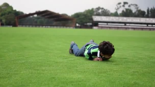 小男孩在草地上打滚 玩得很开心 — 图库视频影像