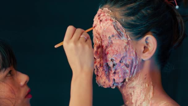 一位特效画家在一位年轻女演员的脸上涂了恐怖的假面 — 图库视频影像