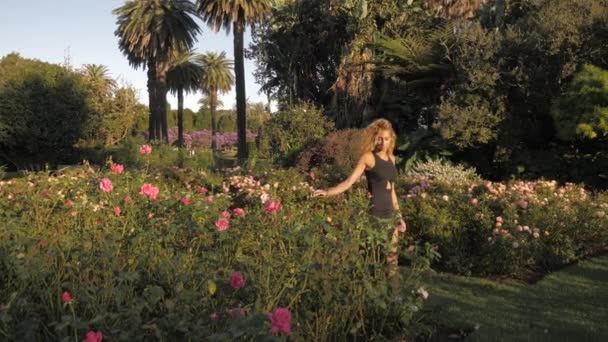 Gyönyörű nő sétál át egy virágos kert - Centennial Park - Sydney Ausztrália egy napsütéses napon - széles lövés