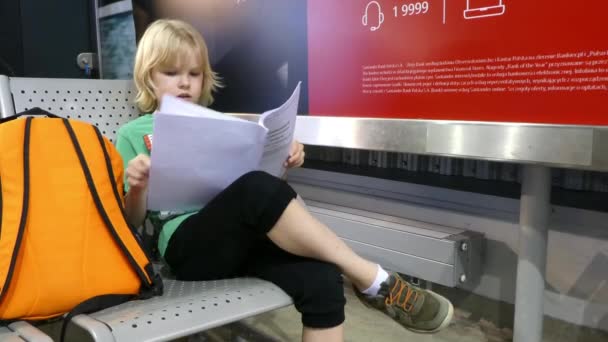 在机场的那个男孩正在看书 等着飞机 — 图库视频影像