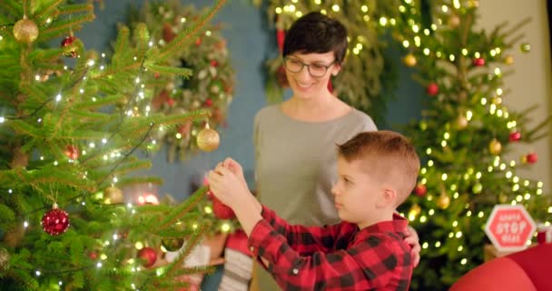 Pyšná Maminka Dívá Svého Syna Zdobí Vánoční Stromeček — Stock video