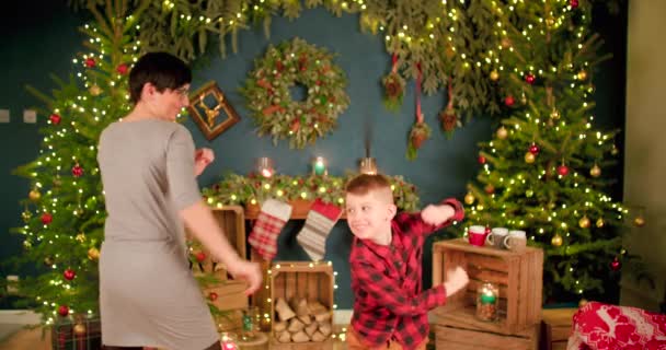 母と息子はクリスマスの装飾の前で楽しみのための戦いをしています — ストック動画