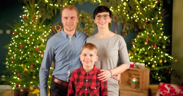 お祝いの装飾されたクリスマスツリーと背景の前に立つ幸せな家族 — ストック動画